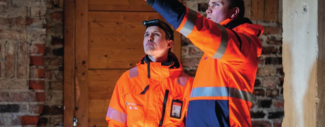 Kaksi Korpisähkön asentajaa tarkastamassa kiinteistön sähköjä
