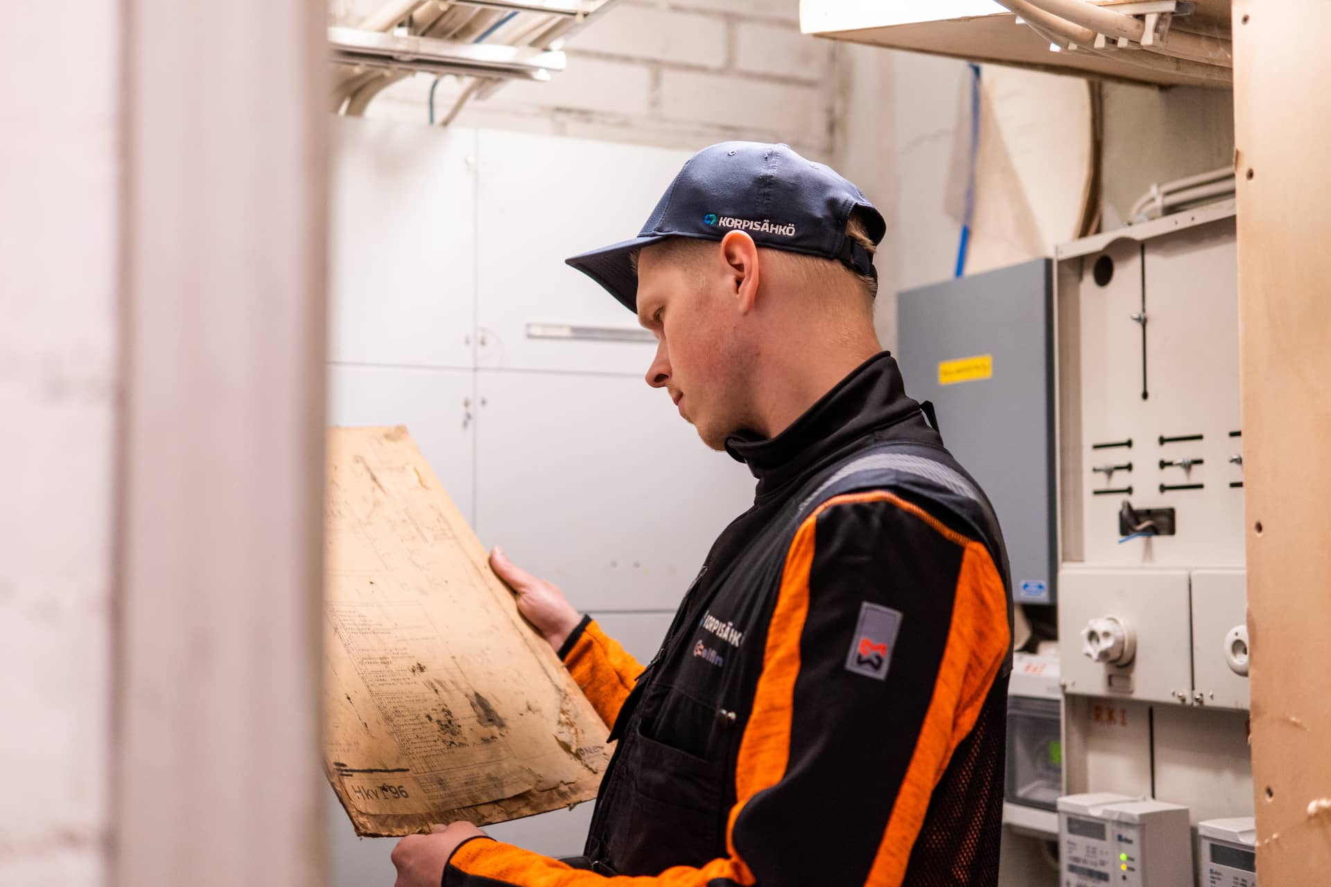 Korpisähkön sähköasentaja työskentelee taloyhtiön sähkötilassa
