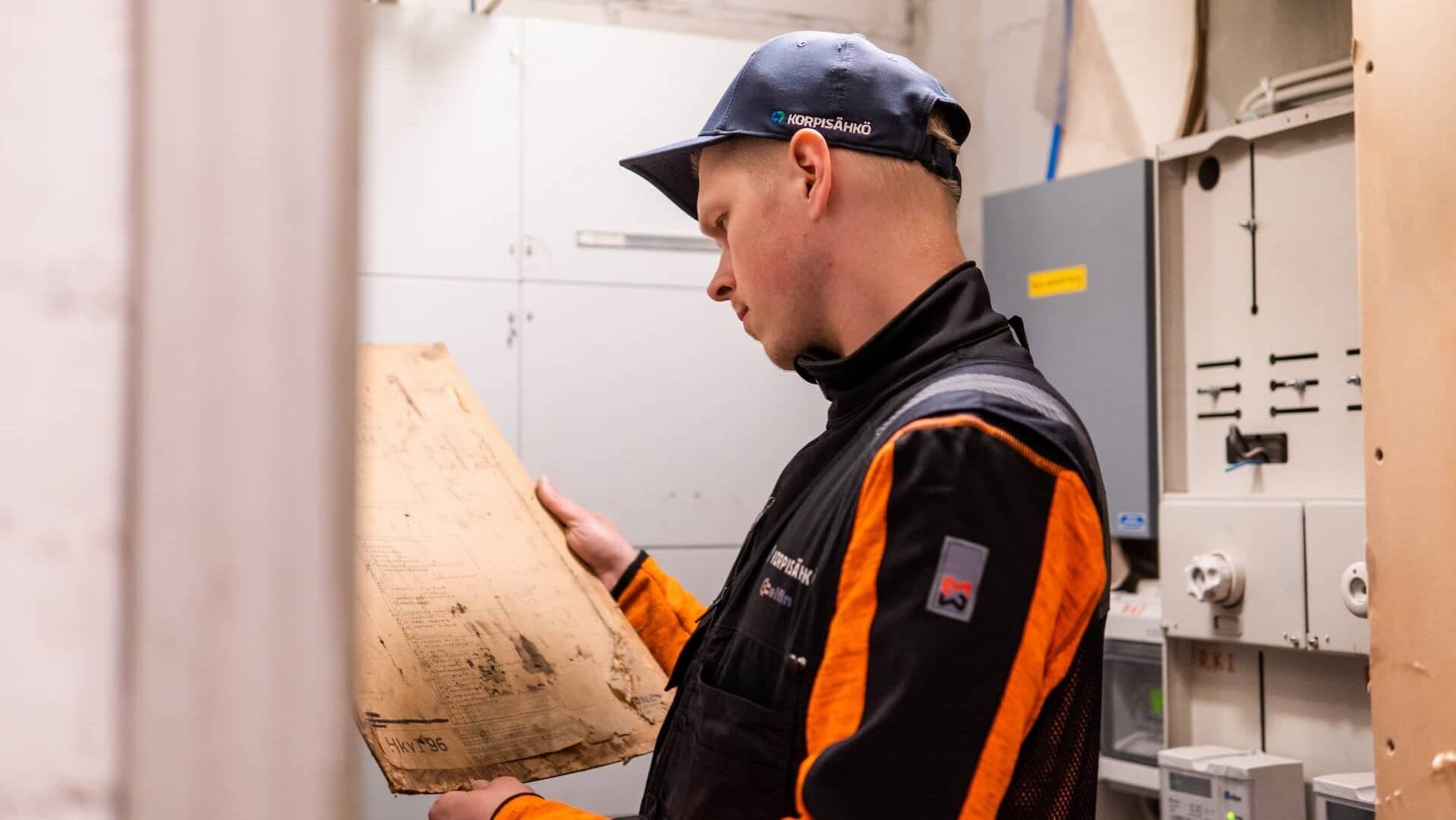 Korpisähkön sähköasentaja työskentelee taloyhtiön sähkökaapilla